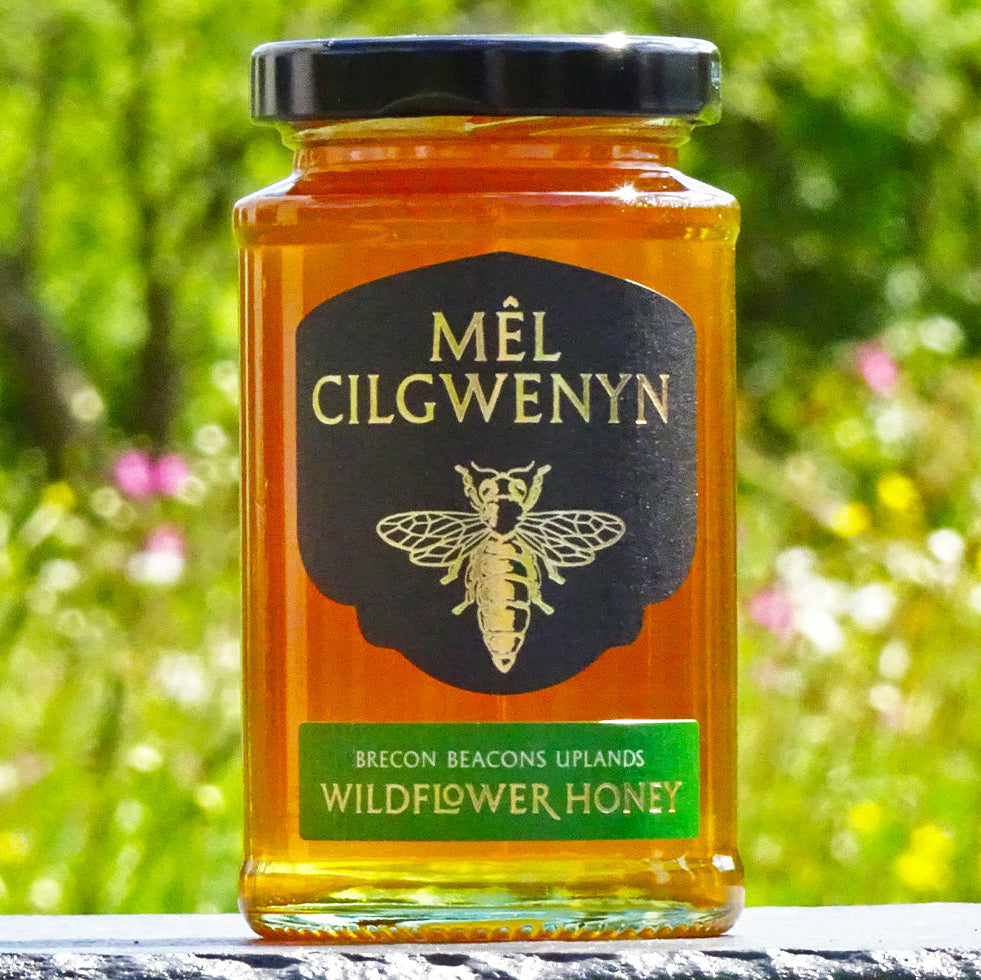 Jar of Mél Cilgwenyn wildflower honey with a blurred natural background